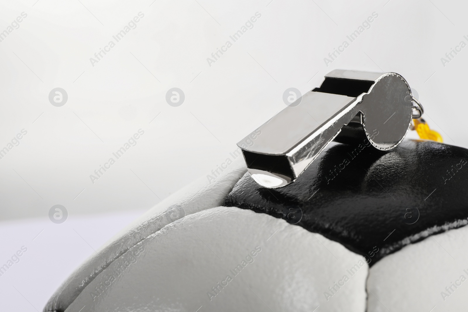 Photo of Football referee equipment. Soccer ball and whistle on white background