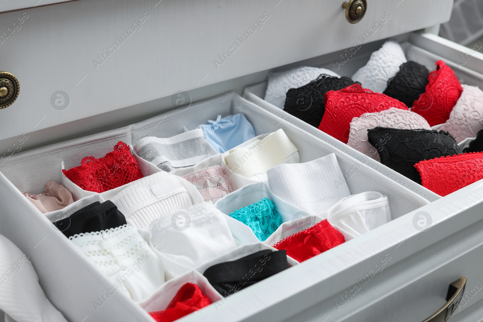 Photo of Organizers with beautiful women's underwear in drawer, closeup