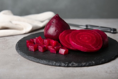 Slate plate with cut boiled beets on table