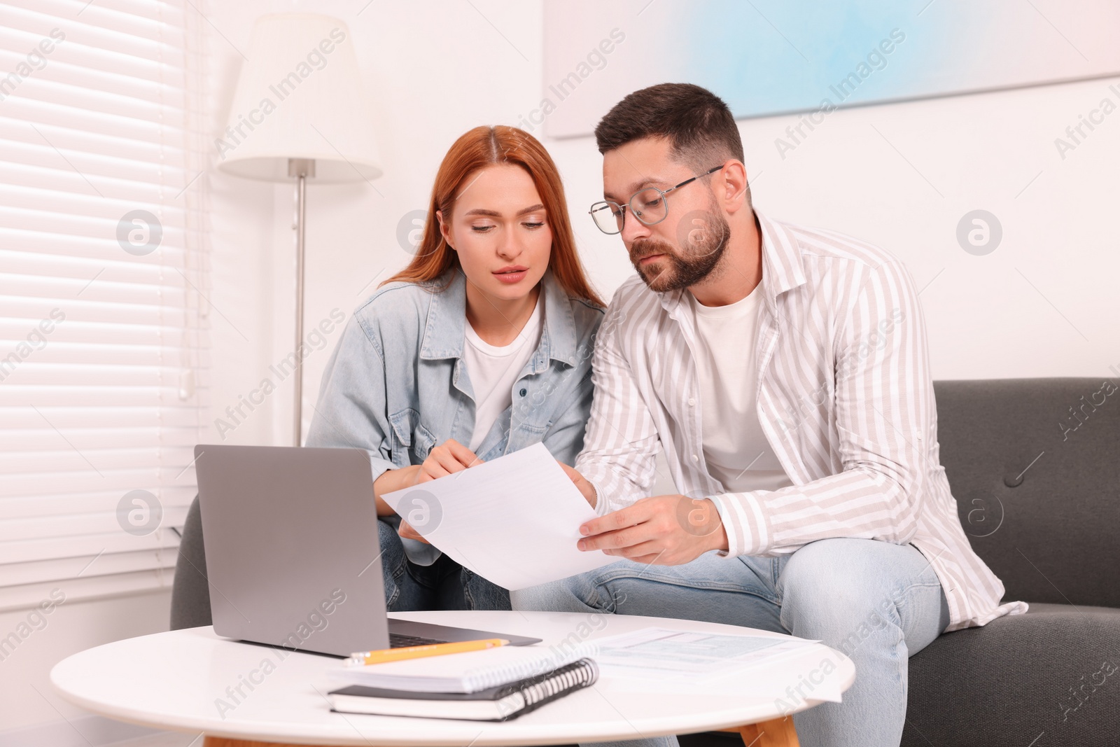 Photo of Couple doing taxes at table in living room