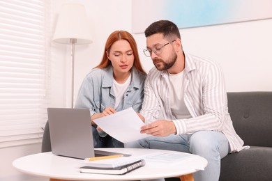 Photo of Couple doing taxes at table in living room