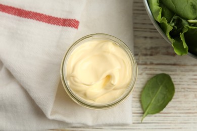 Photo of Jar of delicious mayonnaise and fresh spinach on white wooden table, flat lay