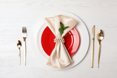 Photo of Festive table setting with plates, cutlery and napkin on wooden background, flat lay