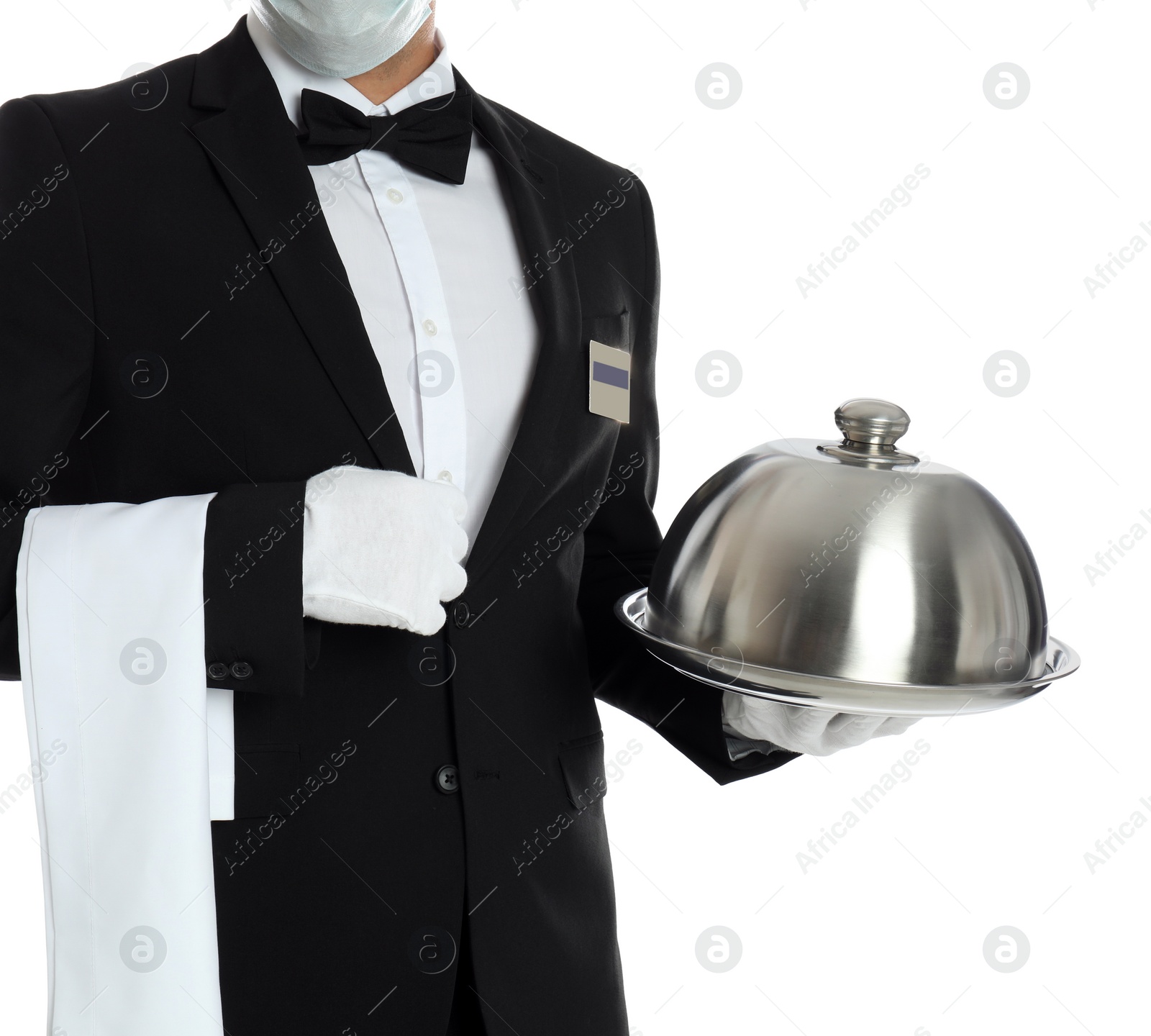 Photo of Waiter in medical mask holding tray with lid on white background, closeup