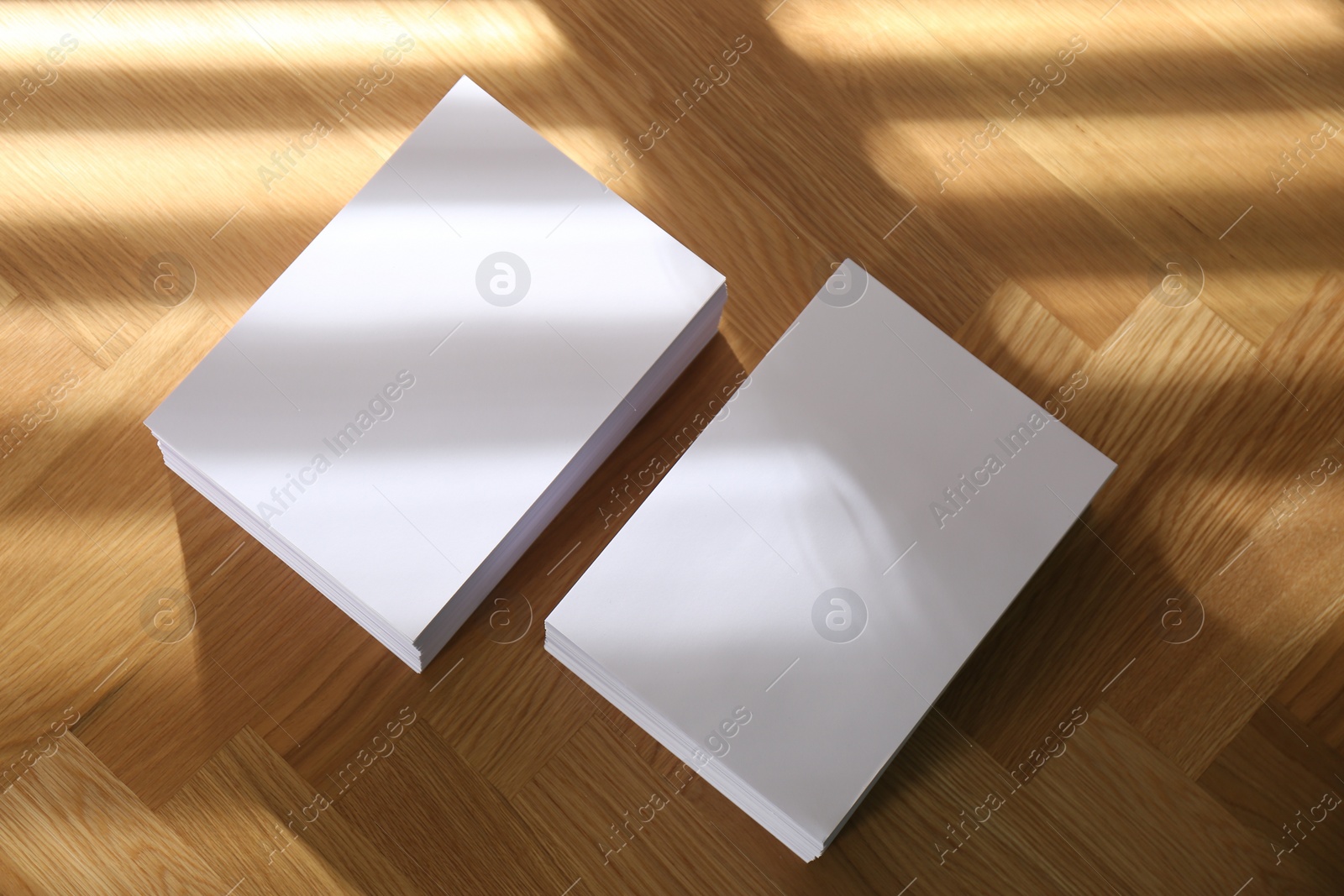 Photo of Stacks of paper sheets on wooden table, above view