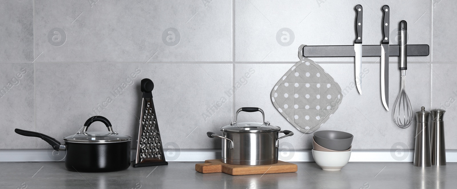 Image of Set of cooking utensils and cookware on grey countertop in kitchen, banner design