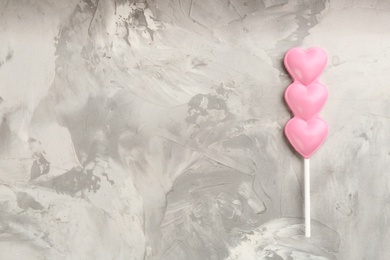 Chocolate heart shaped lollipop on table, top view. Space for text
