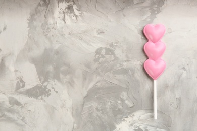 Photo of Chocolate heart shaped lollipop on table, top view. Space for text