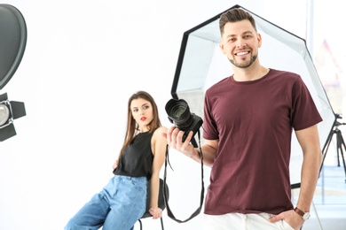 Photo of Beautiful young model with professional photographer in studio