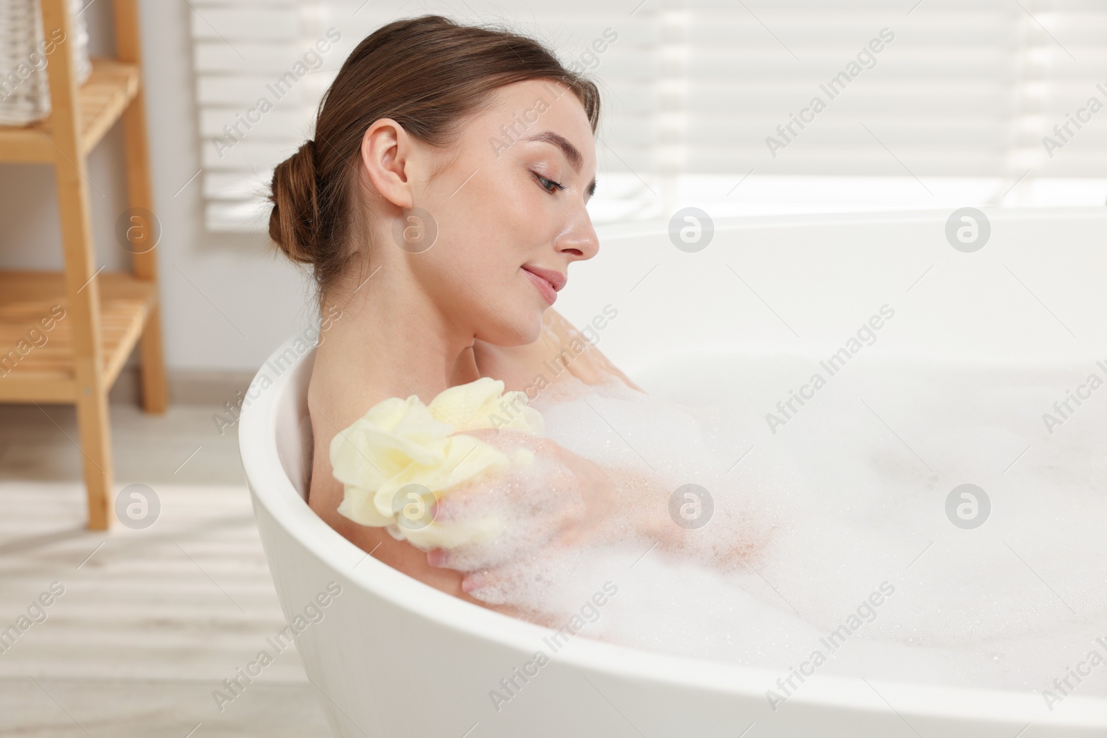 Photo of Woman taking bath with shower gel in bathroom, space for text