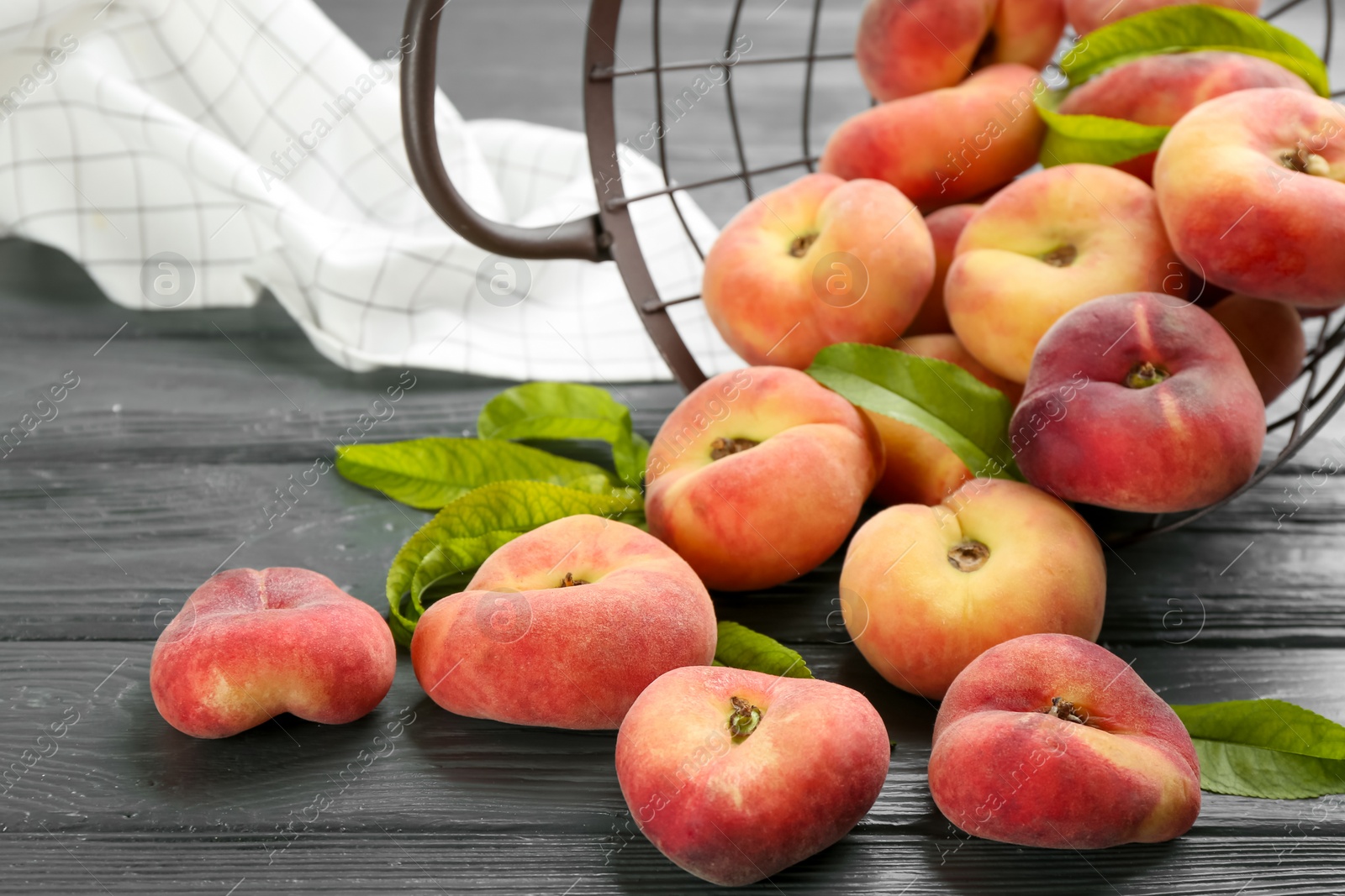 Photo of Fresh ripe donut peaches on grey wooden table