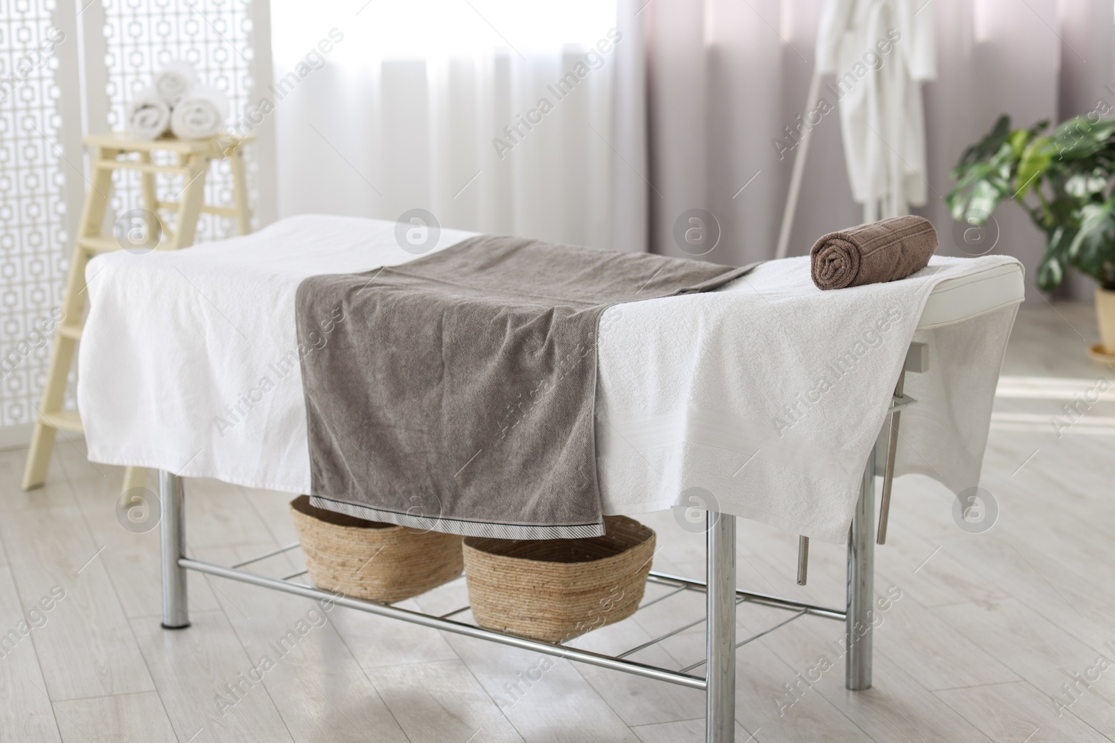 Photo of Comfortable massage table with clean towels in spa center