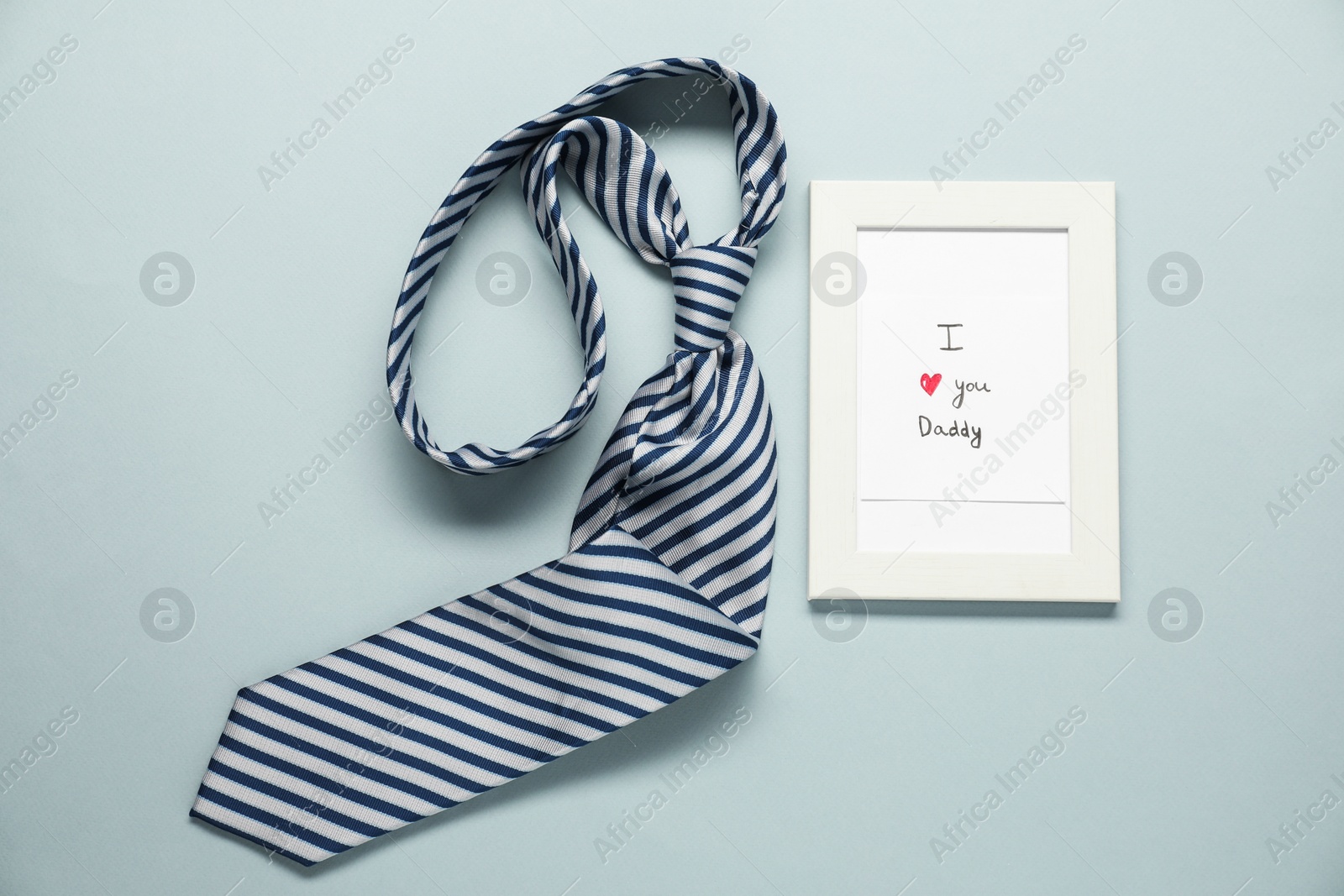 Photo of Father's day celebration. Photo frame with phrase I Love You Daddy and necktie on grey background, flat lay