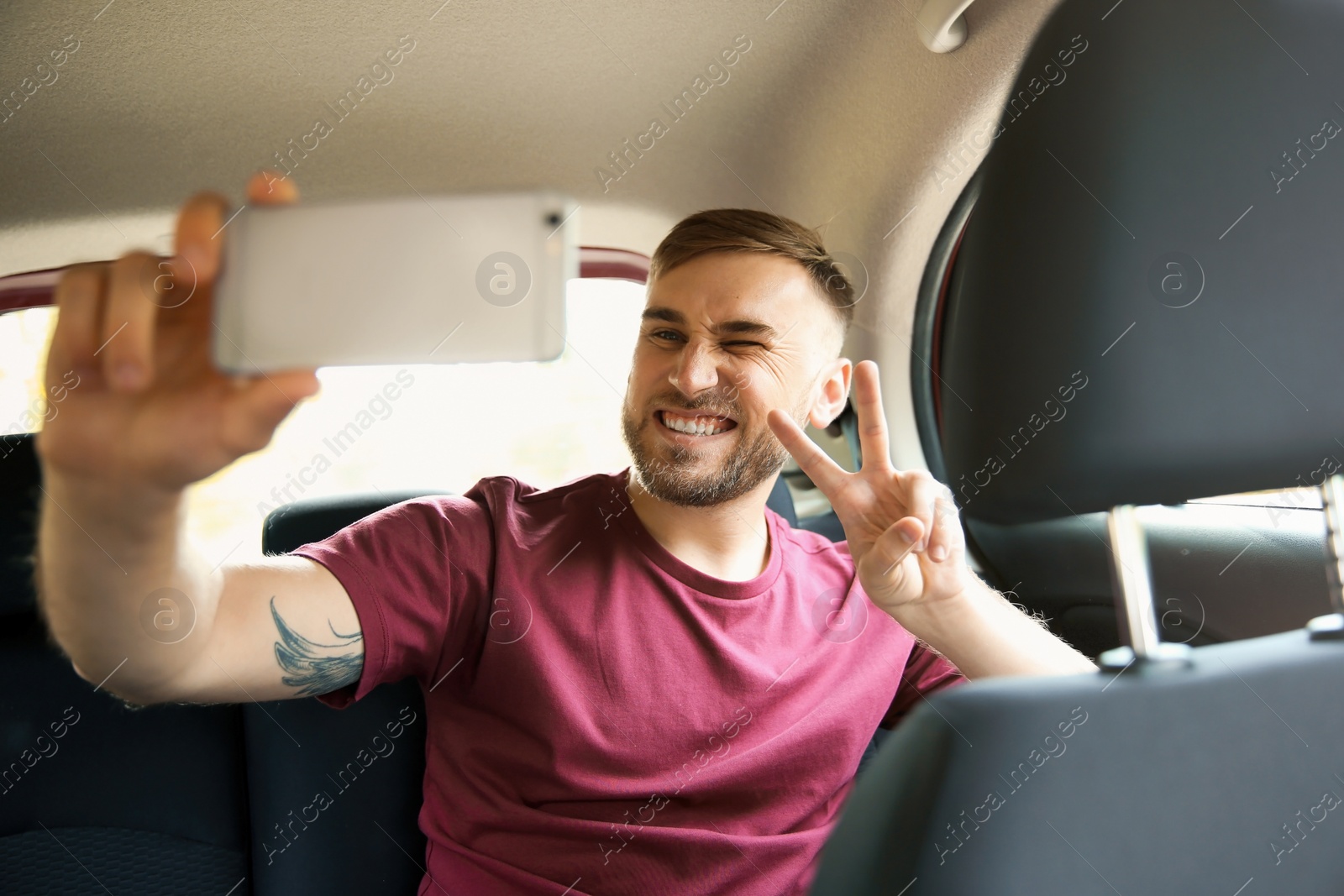 Photo of Happy young man taking selfie in car