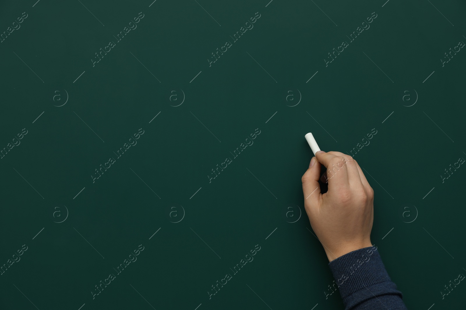 Photo of Man with white chalk near green board, closeup. Space for text