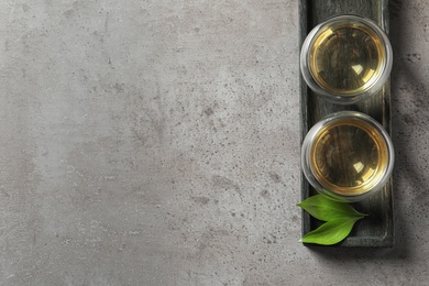 Photo of Glass cups of freshly brewed oolong tea on table, top view. Space for text