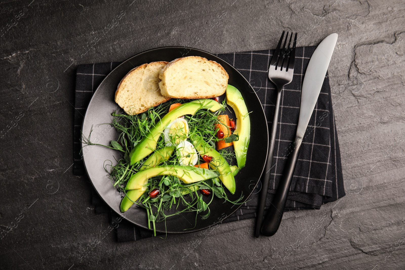 Photo of Salad with fresh organic microgreen in plate on black table, top view