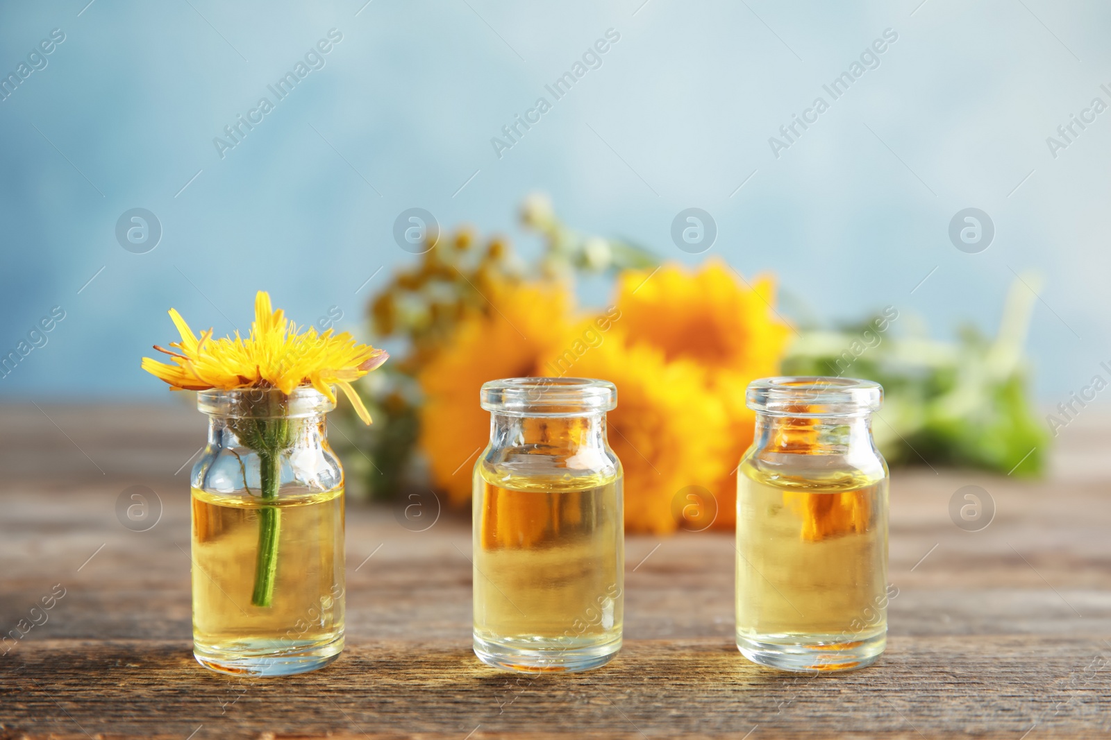 Photo of Composition with essential oil and flowers on table