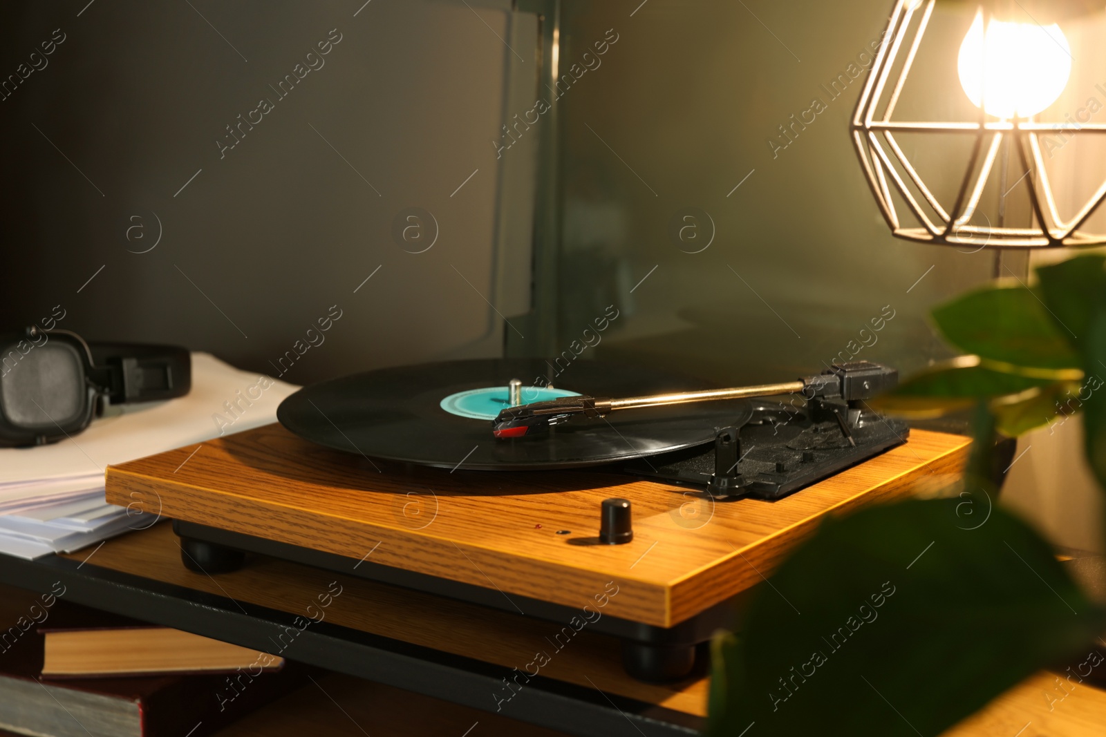 Photo of Stylish turntable with vinyl record on table indoors