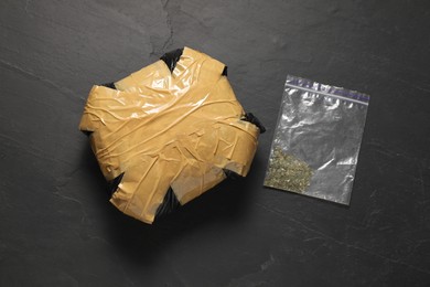 Photo of Packages with narcotics on black table, top view