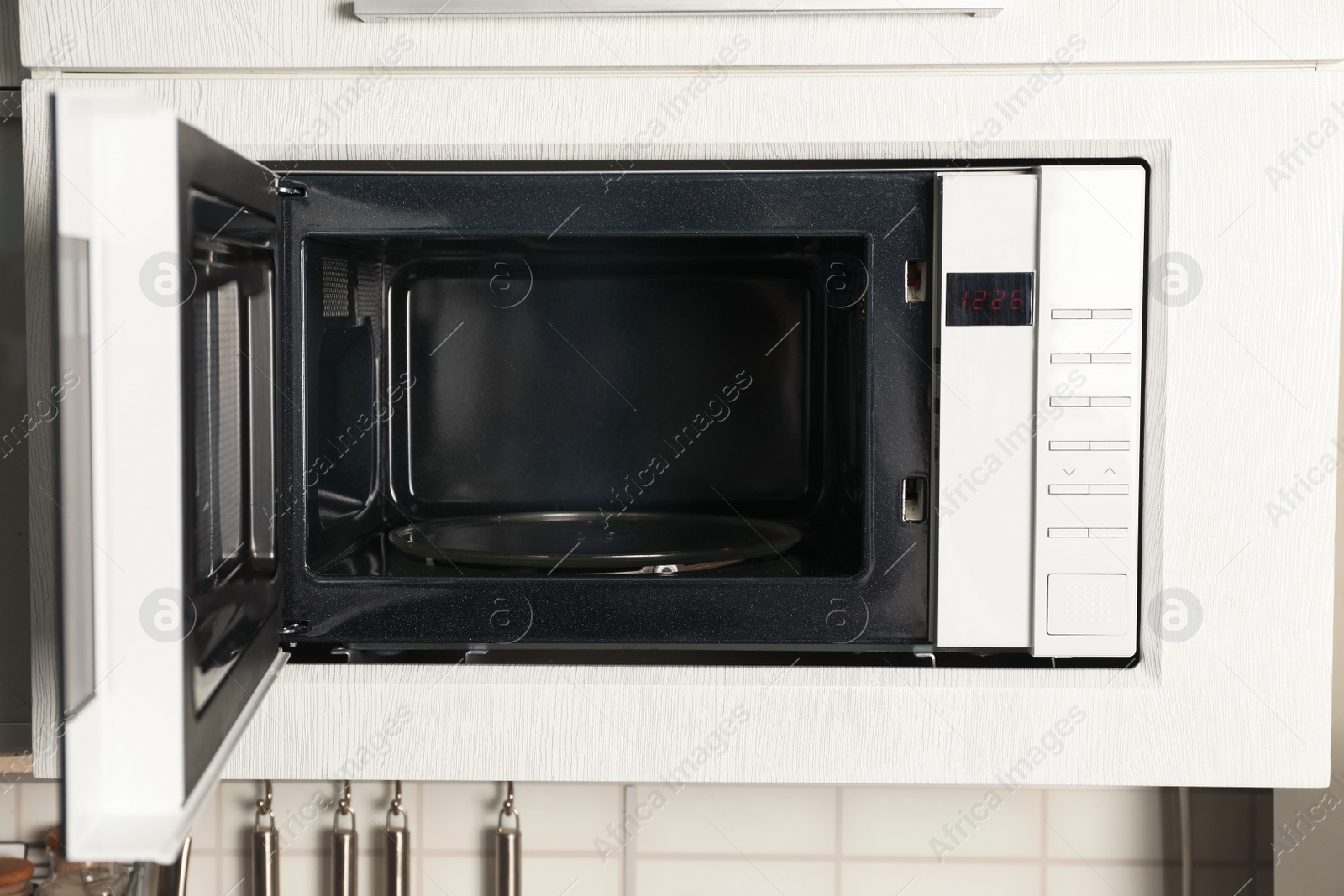 Photo of Open modern microwave oven built in kitchen furniture