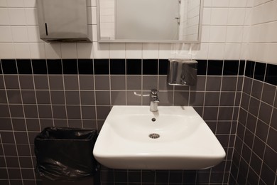 Photo of Public toilet interior with sink and mirror
