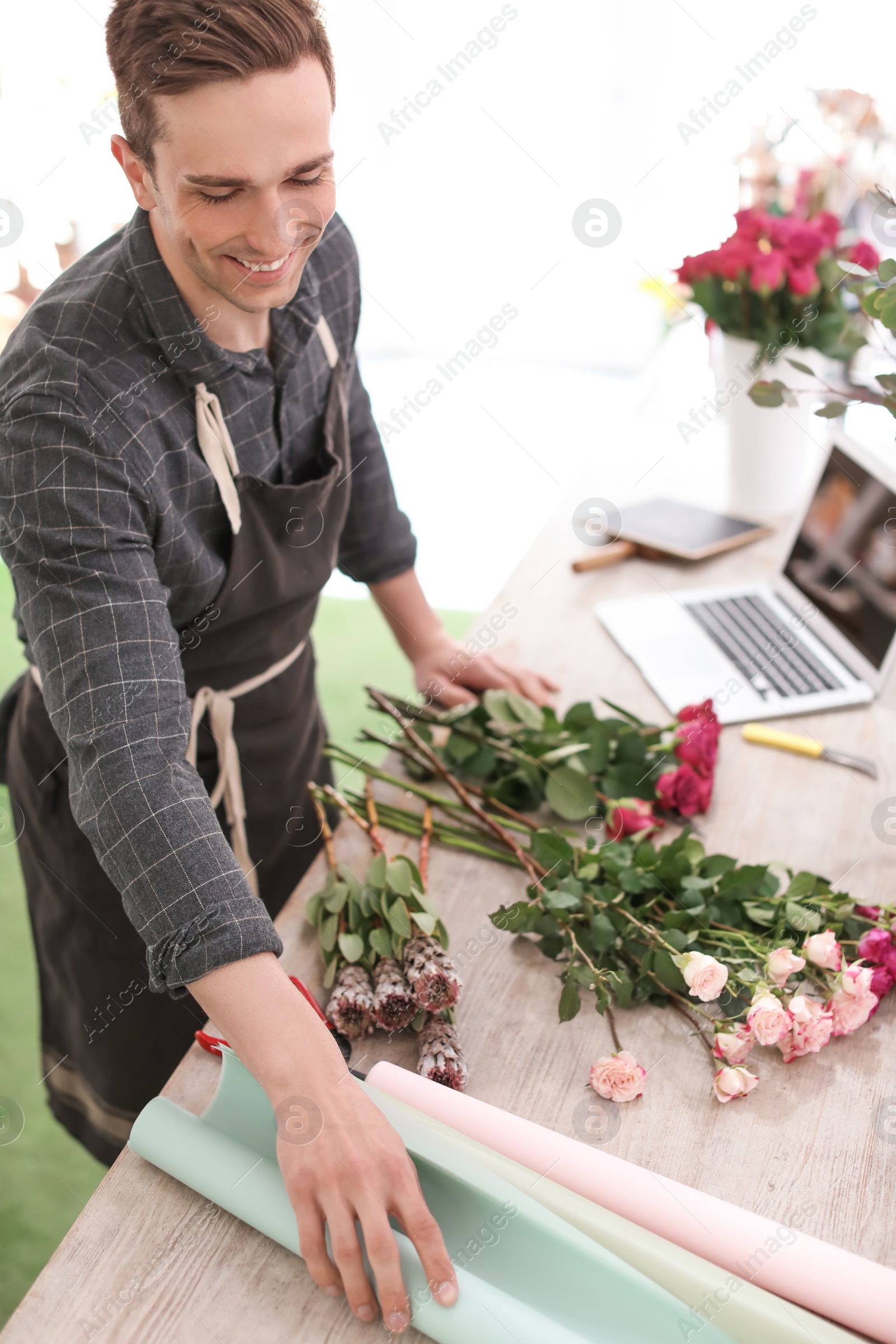 Photo of Male florist creating beautiful bouquet in flower shop