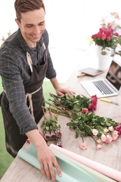 Male florist creating beautiful bouquet in flower shop