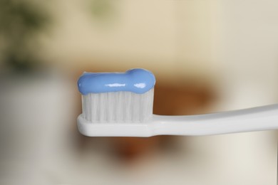 Photo of Plastic toothbrush with paste on blurred background, closeup