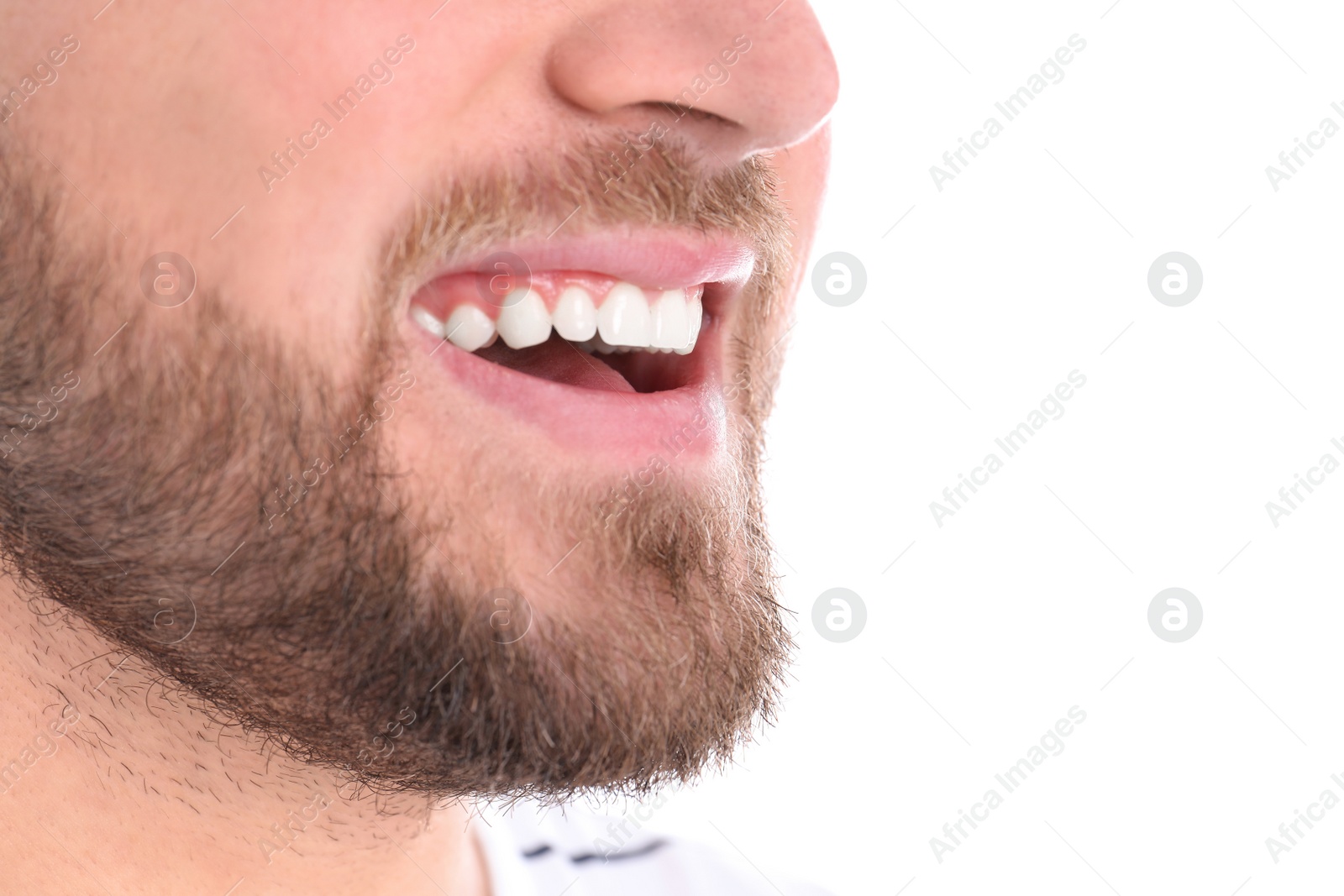 Photo of Young man with healthy teeth smiling on white background, closeup