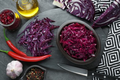 Photo of Tasty red cabbage sauerkraut and ingredients on grey table, flat lay