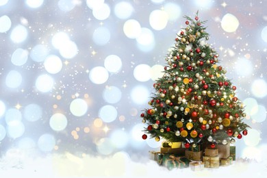 Image of Beautifully decorated Christmas tree and gift boxes on blurred background, space for text. Bokeh effect