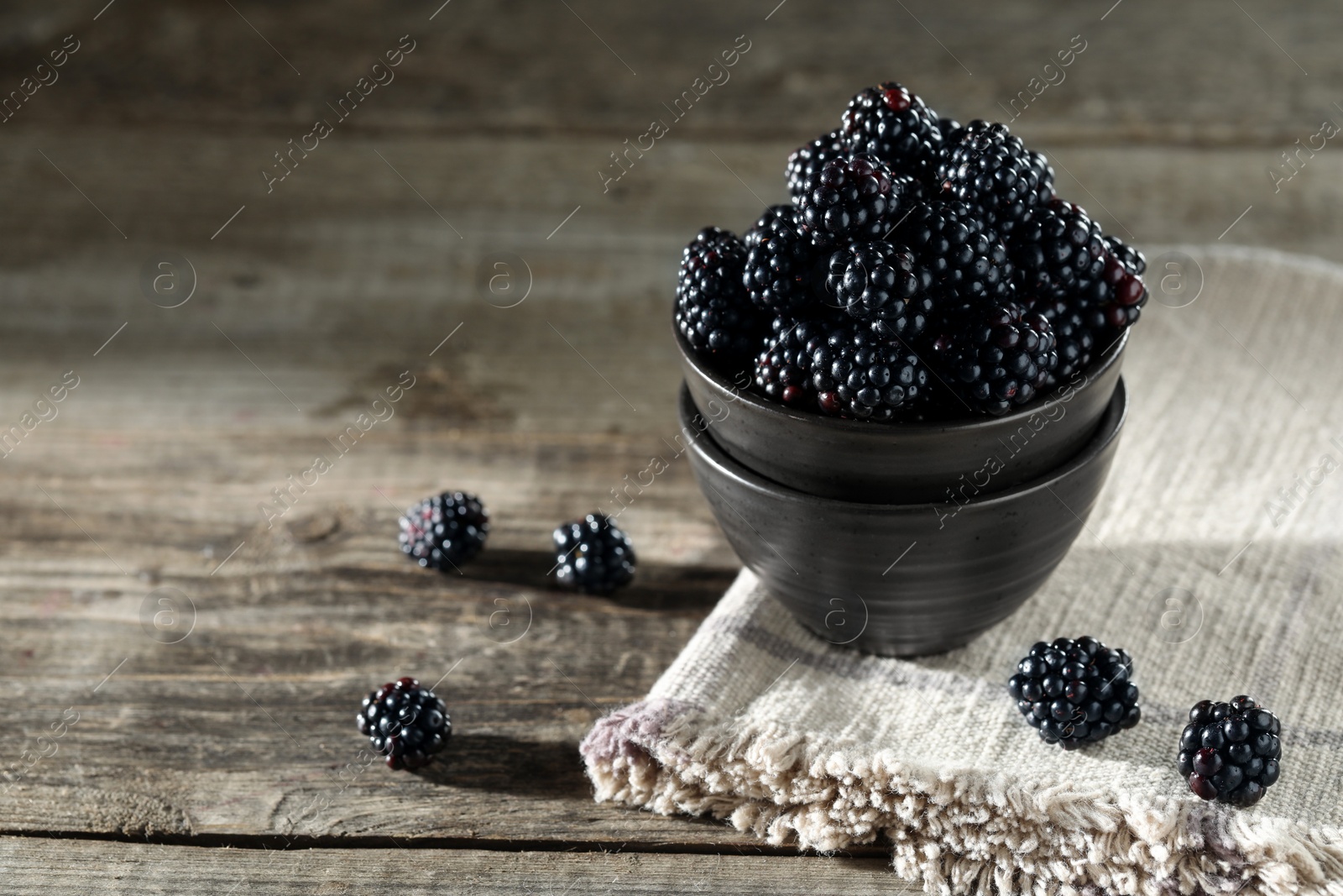 Photo of Fresh ripe blackberries on rustic wooden table. Space for text