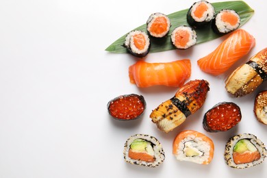 Photo of Different tasty sushi rolls on white background, flat lay. Space for text
