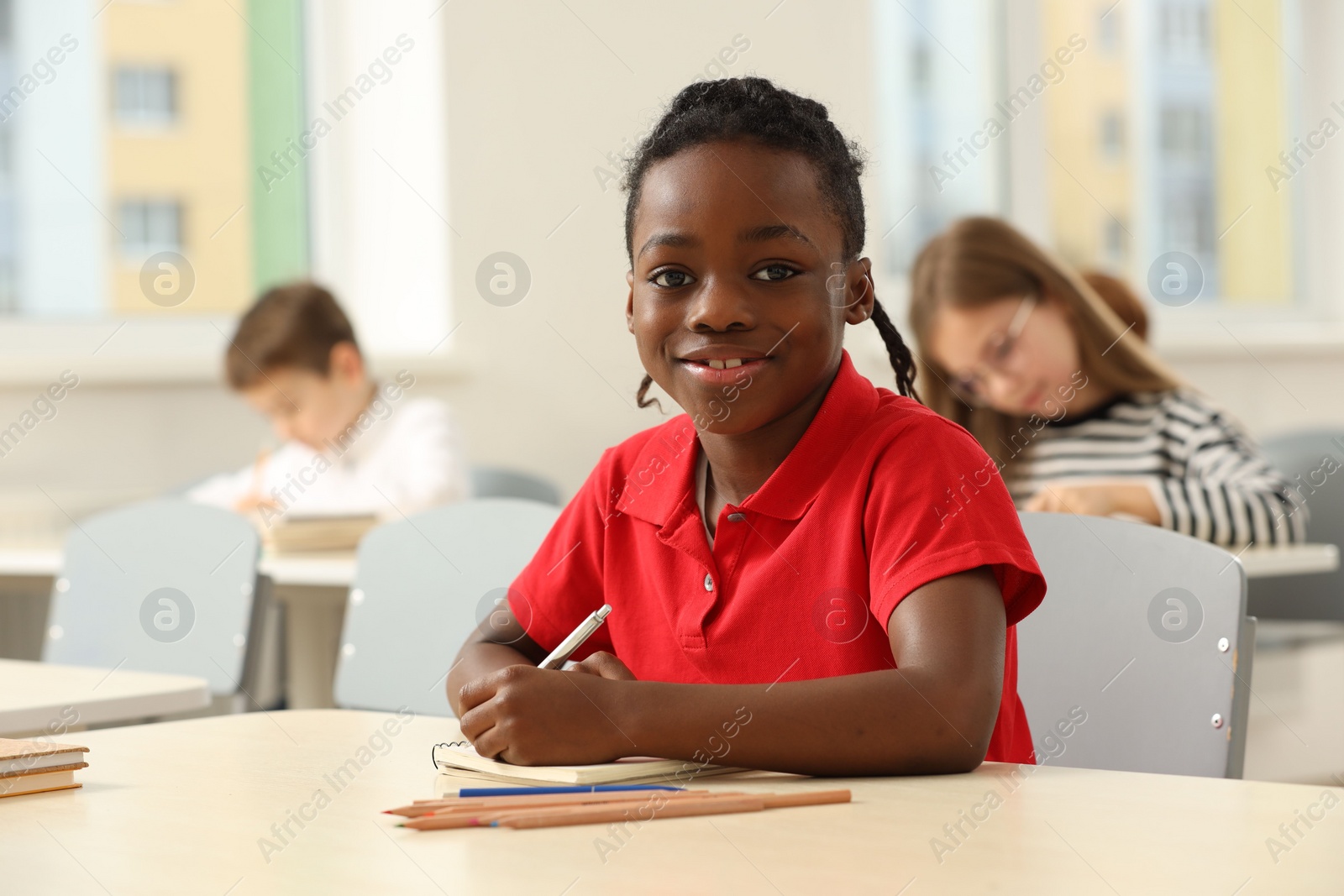 Photo of Portrait of smiling little boy studying in classroom at school