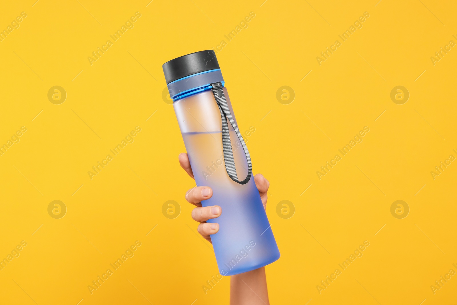 Photo of Woman holding bottle of drink on orange background, closeup