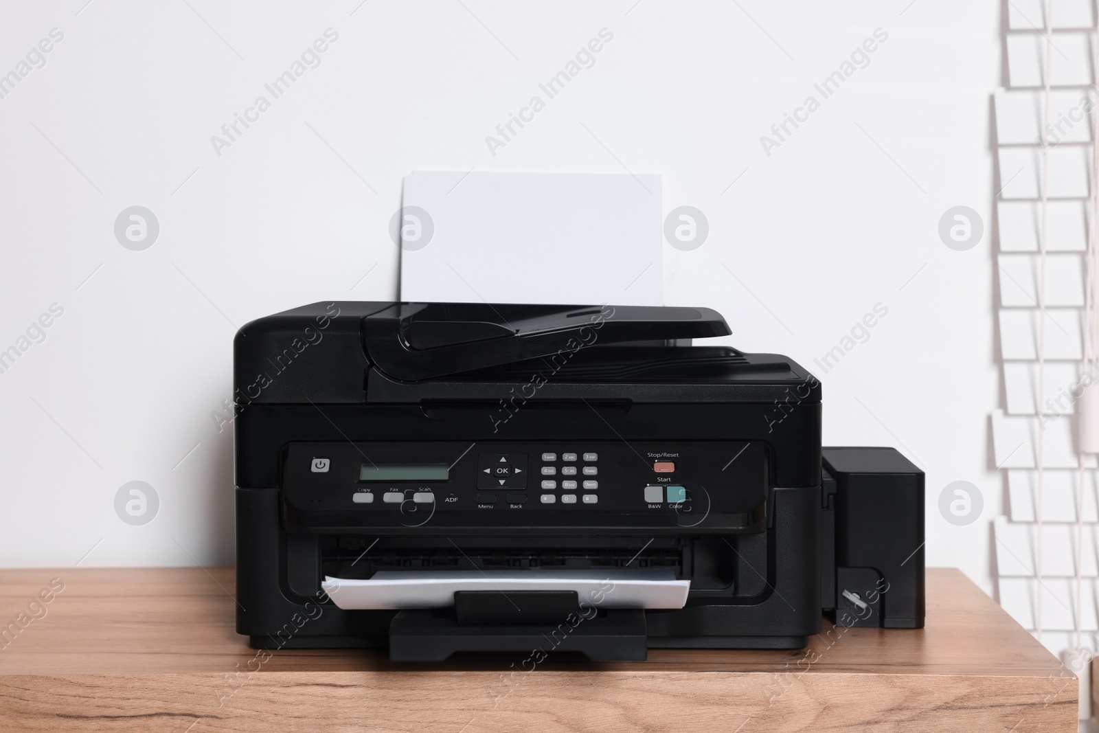 Photo of Modern printer with paper on wooden table indoors