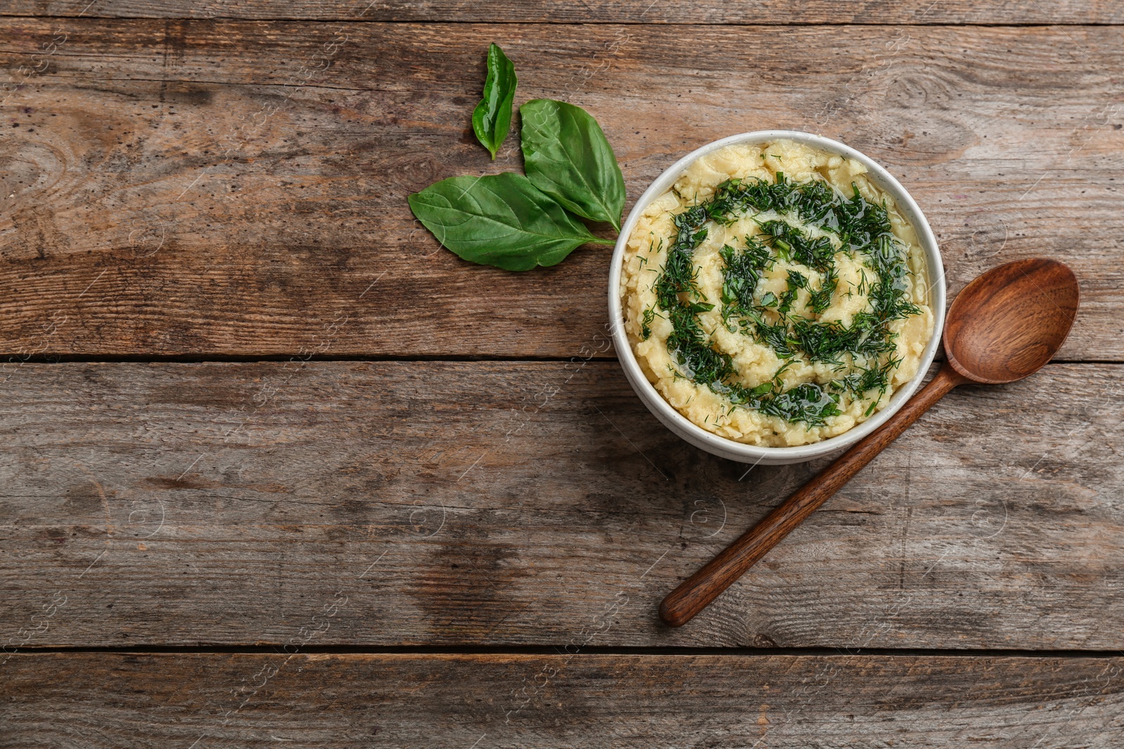 Photo of Flat lay composition with bowl of tasty mashed potato and space for text on wooden table