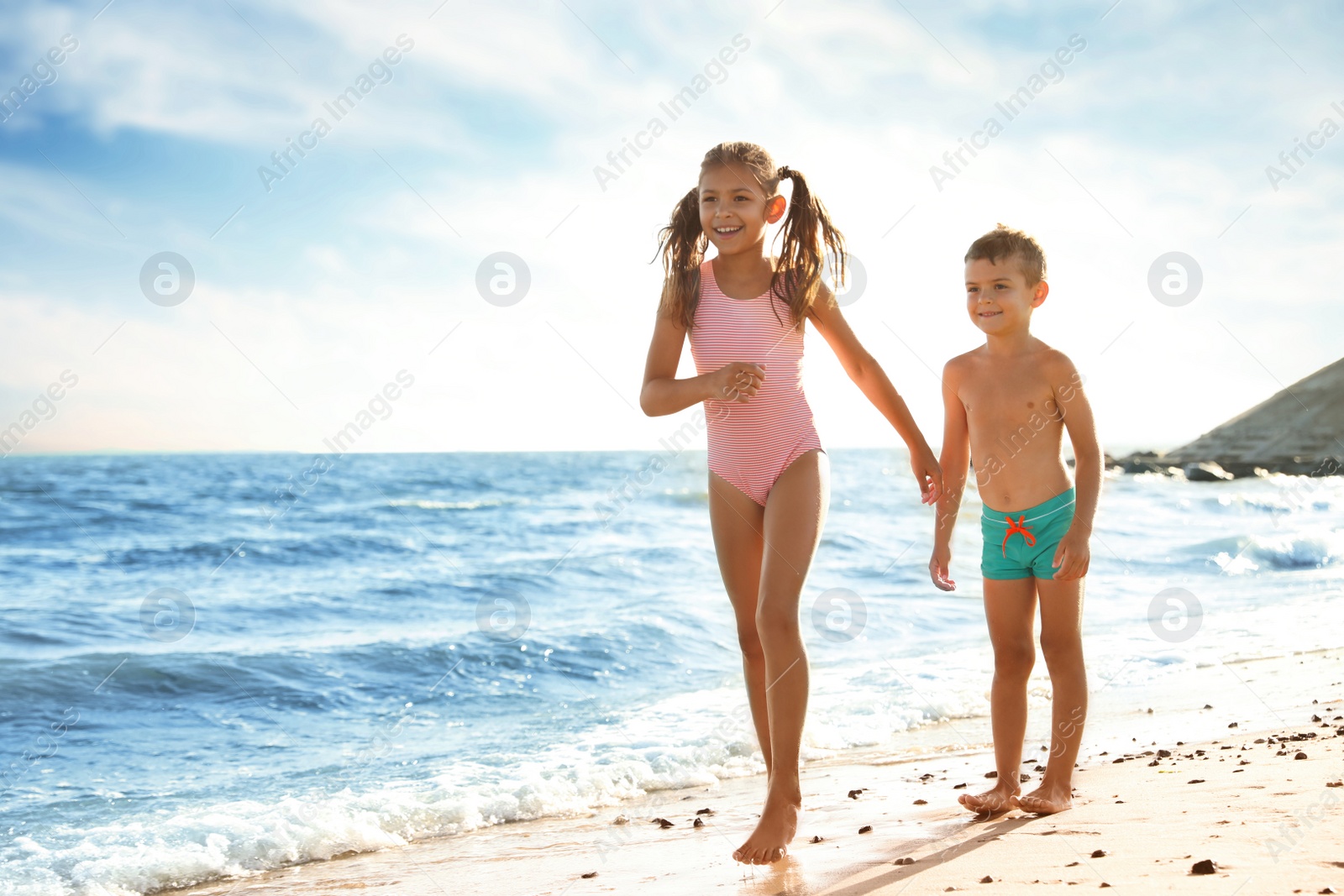 Photo of Cute children enjoying sunny day at beach. Summer camp