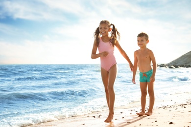 Cute children enjoying sunny day at beach. Summer camp