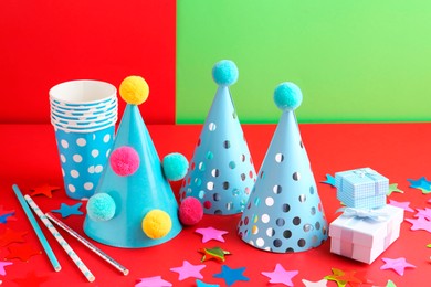 Party hats and other bright decor on color background