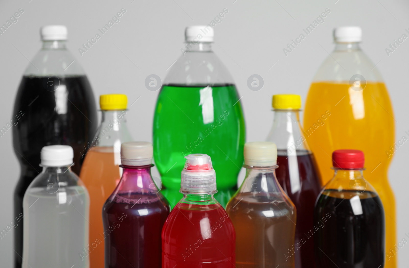 Photo of Bottles of soft drinks on grey background, closeup