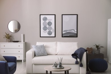 Photo of Stylish living room interior with white sofa, armchair and small coffee table