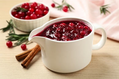 Photo of Cranberry sauce in pitcher on wooden table