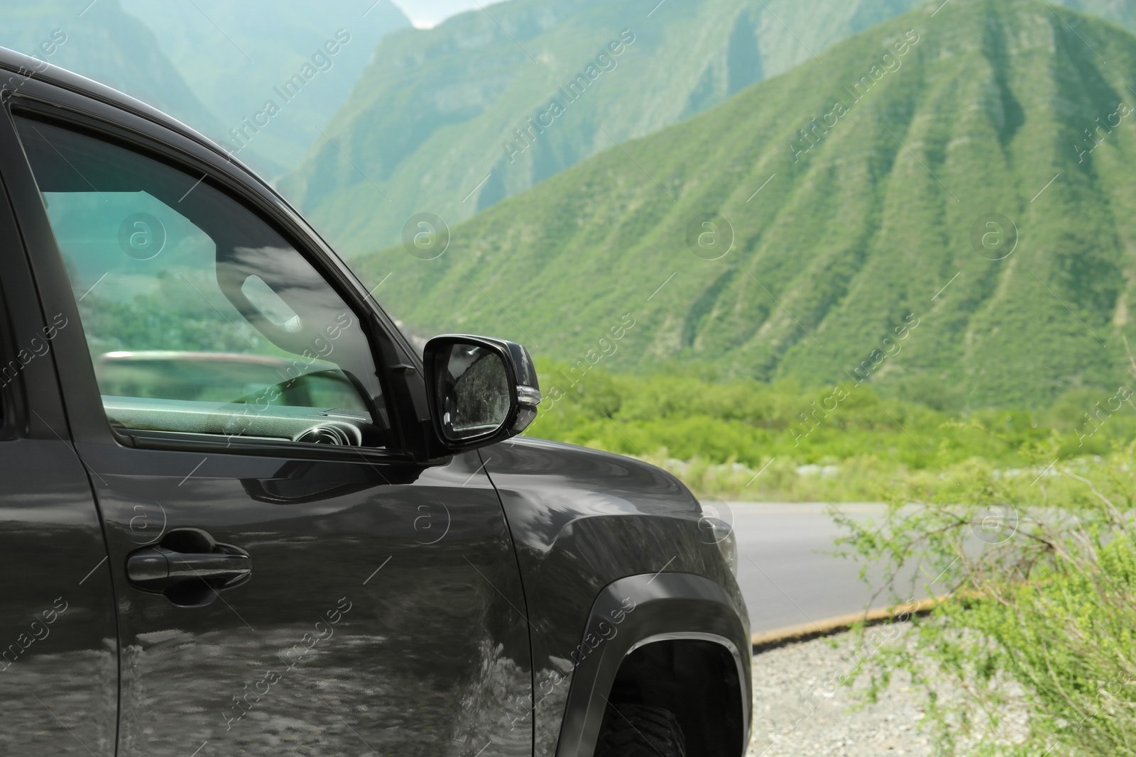 Photo of Black car near beautiful mountains and road outdoors