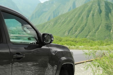 Black car near beautiful mountains and road outdoors