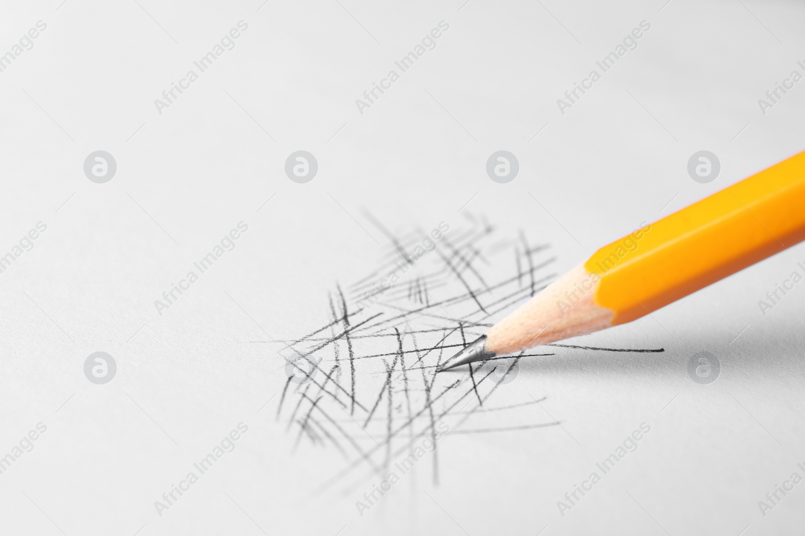 Photo of One sharp graphite pencil and scribbles on white background, closeup. Space for text