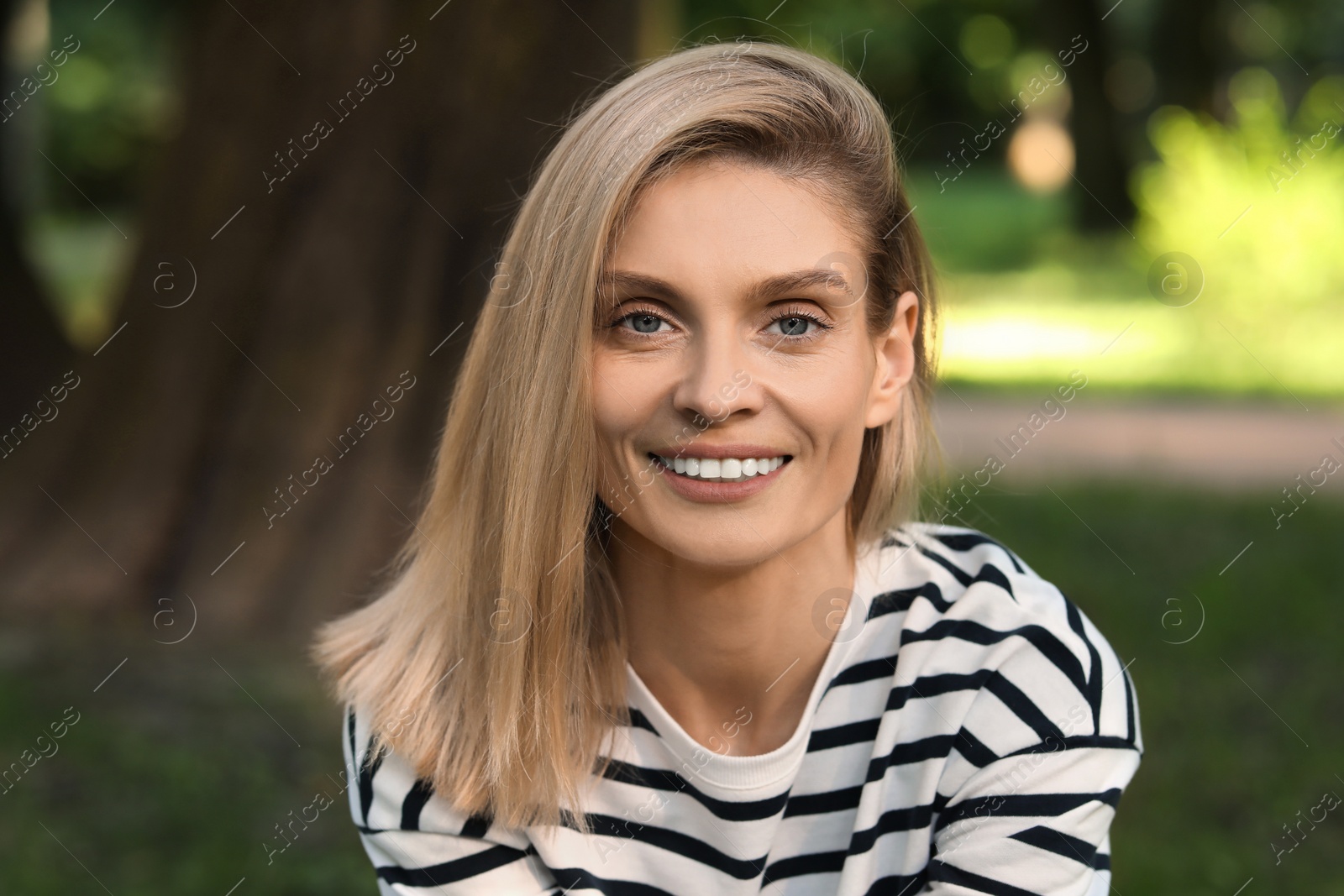 Photo of Portrait of happy woman in casual clothes outdoors. Attractive lady smiling and looking into camera