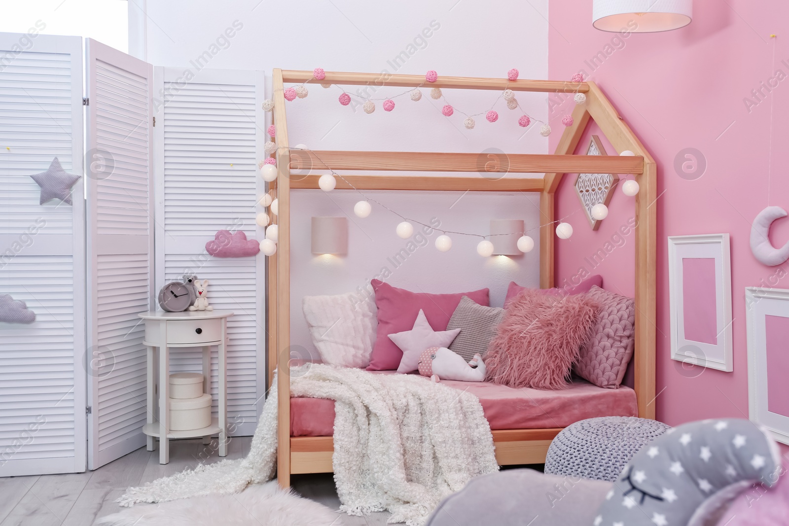 Photo of Child's room interior with comfortable bed and garland