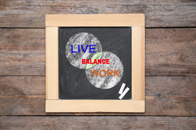 Image of Work-life balance concept. Chalkboard with drawing of intersecting circles on wooden background, top view